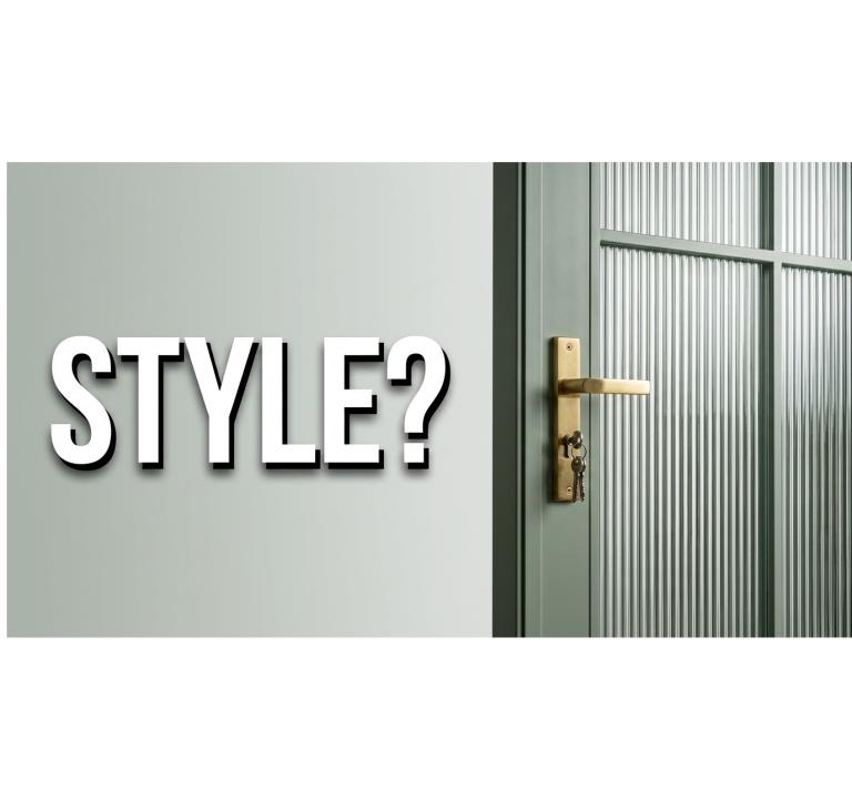 Gray door with gold handle next to a textured wall.